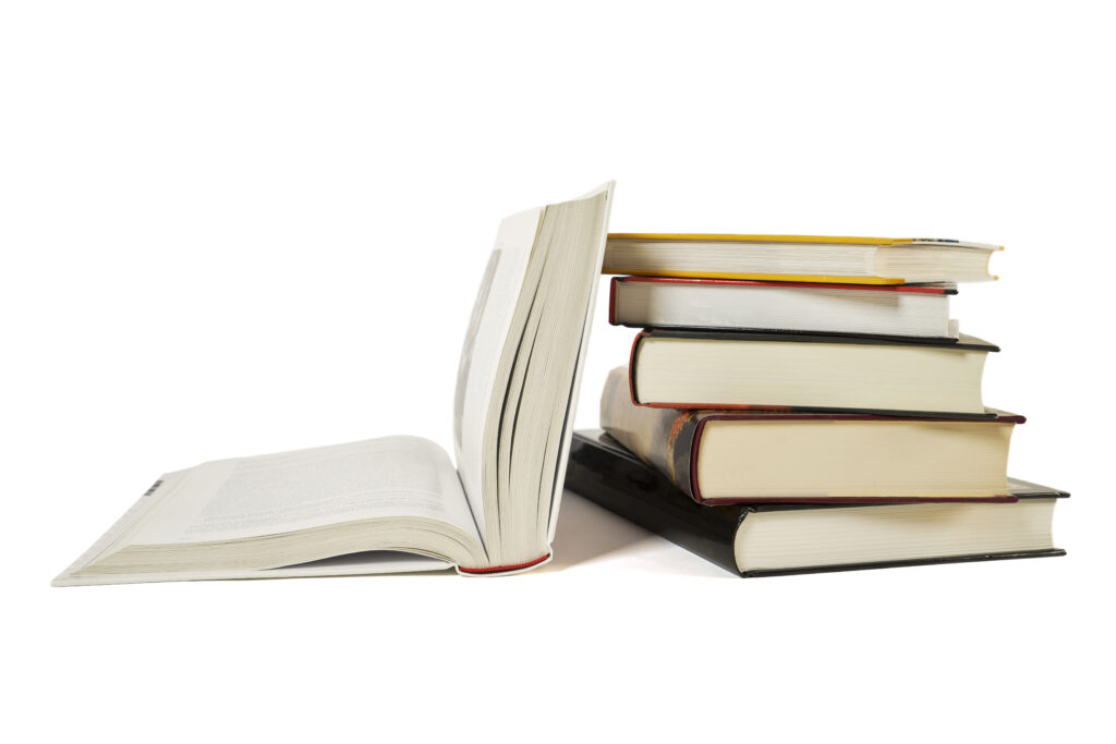 High books stack with open book isolated on white background. Many colorful book covers.